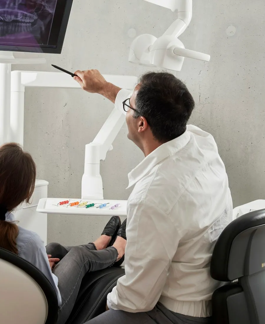 Odontólogo mostrando radiografías a una paciente durante la evaluación
