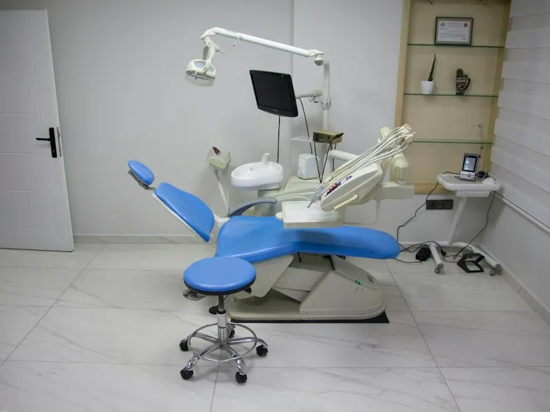 Sillón dental azul en una sala de tratamiento iluminada