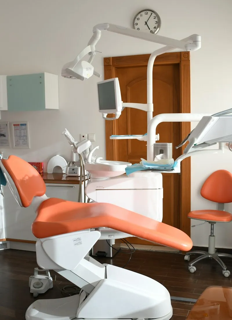 Sillón dental naranja en una sala de tratamiento moderna