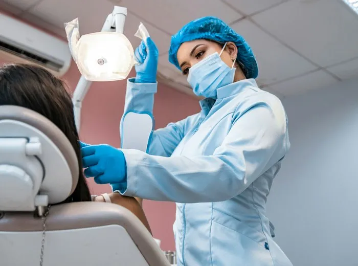 Especialistas atendiendo un tratamiento dental con luz de trabajo en la clínica